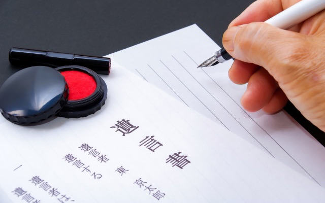 遺言書を作成している人の手元と書類